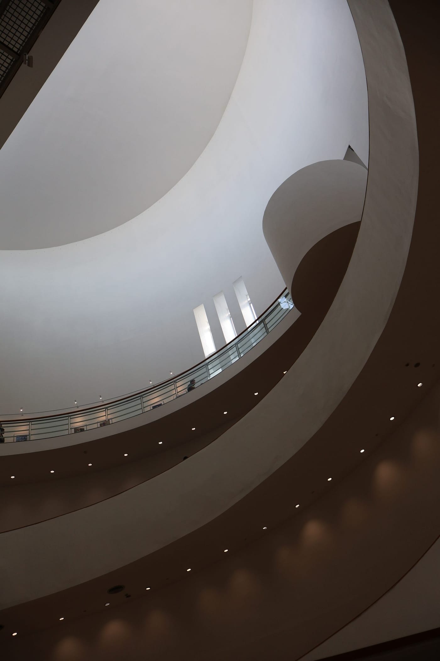 Curved white balconies winding upward through a tall interior