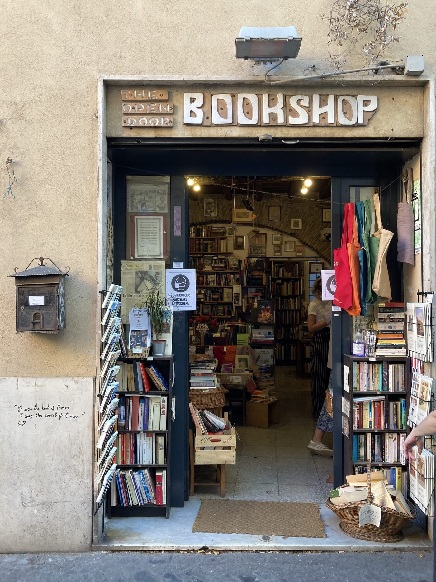 The open door of a small bookshop with books stacked outside
